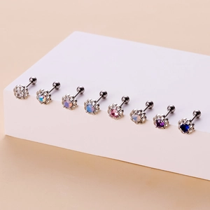 Set of eight colorful sunflower cartilage studs with screw backs on a white display