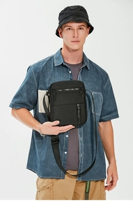 Detail of waterproof black crossbody bag with multiple zippers and adjustable strap
