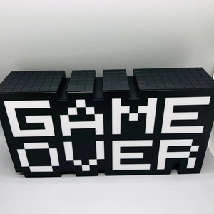 Front view of black GAME OVER LED pixel lamp with white lettering on white background