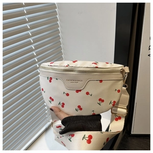 Detail of white PU leather crossbody bag featuring red cherry prints and gold hardware zippers