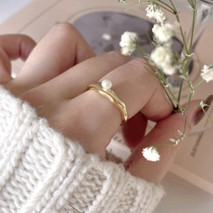 Detailed view of irregular wavy 18K gold-plated band featuring a lustrous white pearl
