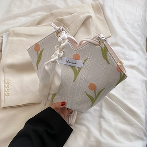 Chic beige canvas tote bag with orange tulip embroidery and ribbon wrapped handle