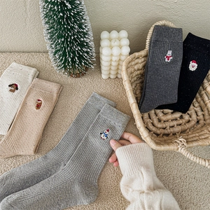 Calze natalizie in maglia in cinque colori con ricami festivi e decorazioni invernali accoglienti