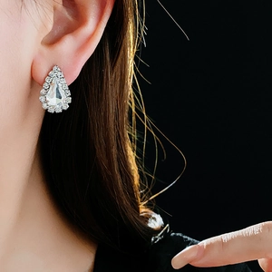 Gros plan de boucles d'oreilles goutte d'eau avec cristaux portées par un mannequin chic