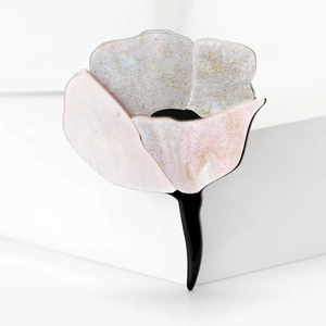 Detail of flower hair clip with light pink petals and shimmering glitter finish