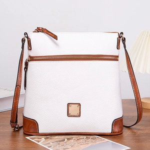 Macro shot of white lychee leather texture and brown edge stitching on crossbody bag
