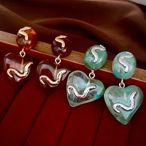 Elegant acrylic heart drop earrings in amber brown and marble green with metal accents
