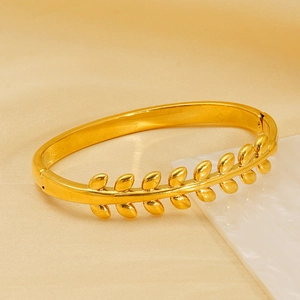 Bracelet jonc élégant en acier titane doré en forme de feuille sur marbre blanc
