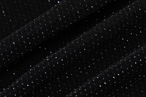 Vue macro du tissu en maille noir avec paillettes argentées et détails de texture fins