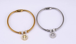 Detail of snake chain bracelets with crystal pavé cross charms in gold and silver