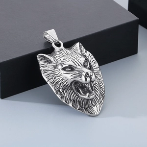Macro shot of silver viking wolf head pendant with intricate metallic texture details