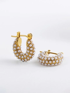 Detail of 18K gold plated twisted hoop earrings with micro-inlaid pearls on white background