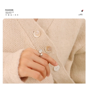 Detailed view of silver minimalist open ring with rectangular metal accents on finger