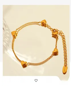 Detail of gold heart pendant bracelet with double chain and S.steel engraved tag