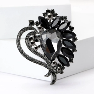Macro detail of high-quality black pear-shaped crystal brooch with floral metal setting