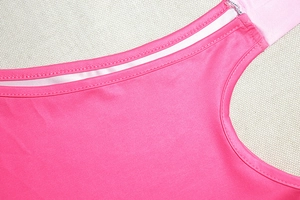 Dettaglio del tessuto rosa pesca ad alta elasticità con cuciture di precisione a due aghi