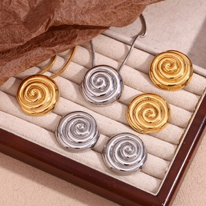 Macro view of gold and silver swirl shell jewelry set in a beige velvet display box