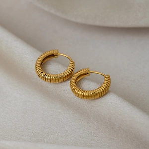 Striped 18K gold-plated stainless steel hoop earrings on a soft cream silk background