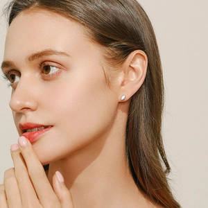 Elegant S925 sterling silver marquise opal stud earrings worn by a model on a beige background
