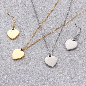 Détail de parure bijoux coeur en acier inoxydable doré et argenté avec émail rouge brillant