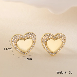 Detail view of 1.1x1.2cm 18K gold plated heart stud earrings with cubic zirconia border