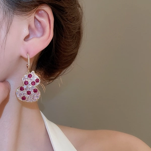 Detailed close-up of a zircon gourd C-shaped earring in gold plating on a model ear
