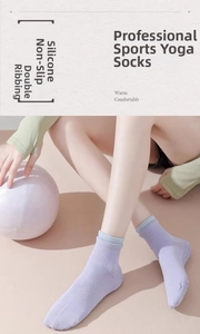Detailansicht der Silikon-Anti-Rutsch-Noppen und Rippbündchen an lila Yoga-Socken