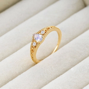 Close-up of vintage teardrop labradorite ring with gold filigree and diamond accents