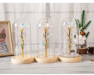 Three holographic foil roses in glass domes with wooden bases and LED light strings