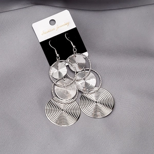 Detail of silver layered hollow round metal earrings with concentric textured pattern
