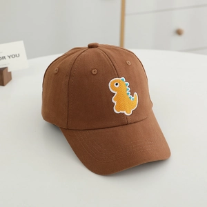 Détail de la broderie de dinosaure jaune sur une casquette de baseball en coton marron
