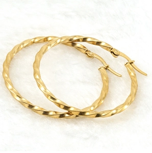 Detail of 18K gold plated stainless steel hoop earrings with textured spiral ripple design