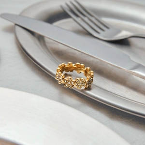 Detail of 18K gold-plated flower ring with zircon stones styled on creative cutlery