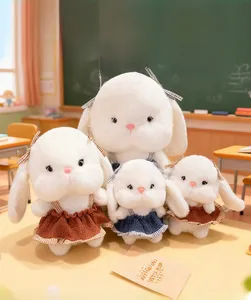 Detail view of white plush rabbit dolls in different sizes wearing knitted strap dresses