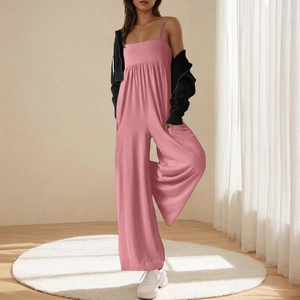 Detail of pink wide-leg jumpsuit with straps styled with a black jacket in home setting