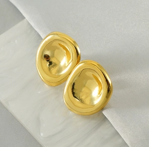 Detail of irregular oval 18K gold plated stainless steel earrings on white silk fabric