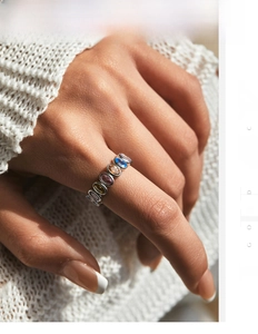 Detail of S925 silver ring with colorful oval gemstones in a bezel setting on a model