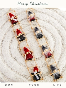 Christmas ladder wall decor with cute felt gnomes and Santa dolls on a soft white rug