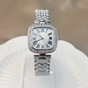 Detailed close-up of a silver square watch featuring crystal-set bezel and blue Roman numerals