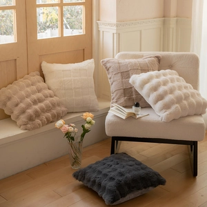 Detail of white and khaki faux rabbit fur pillows with 3D bubble texture for home decor
