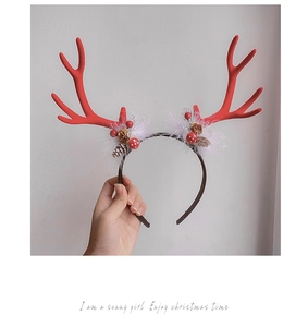 Detail of Christmas reindeer antler headband with pine cones, red berries and white faux fur