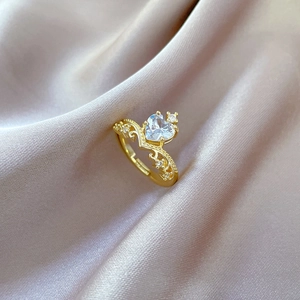 Adjustable gold crown heart ring with full cubic zirconia stones on silk background