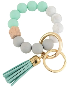 Detail of beaded keychain bracelet with silicone beads, wood bead and mint green tassel