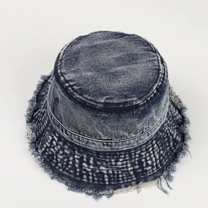 Dettaglio del cappello alla pescatora in denim blu scuro vintage con bordi sfrangiati