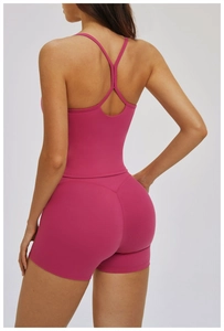 Vue arrière de l'ensemble de yoga rose rouge sans couture avec débardeur et short galbant