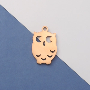 Detailed view of an owl-shaped rose gold pendant with minimalist cutout on dual background