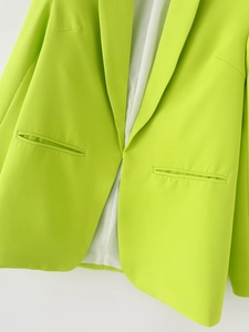 Gros plan détaillé du blazer vert citron avec revers cranté et texture de tissu tissé