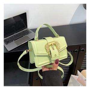 Close-up of lime green mini crossbody bag featuring a vintage gold baroque buckle