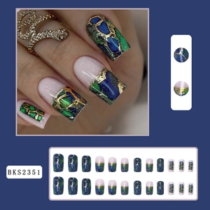 Detail of green snake pattern press-on nails with gold foil accents and 24-piece kit