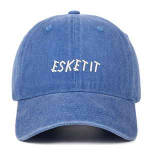 Close-up of the white ESKETIT embroidery on the blue washed denim baseball cap